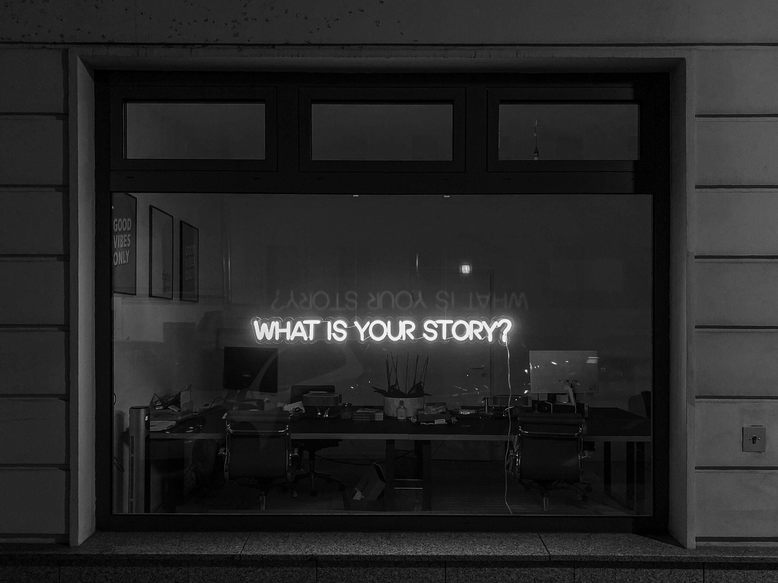 Neon Sign met de vraag wat jouw verhaal is. Foto: Unsplash / Etienne Girardet